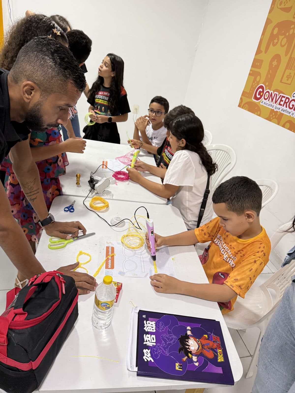 Professora orientando alunos em projeto maker